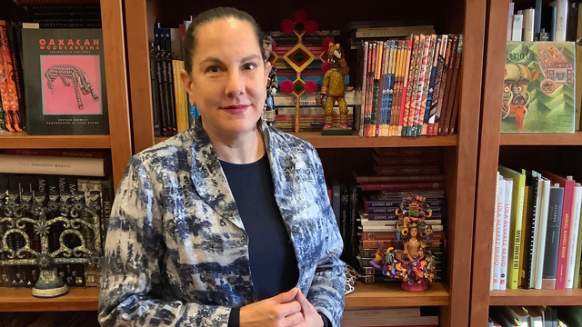 Donor-advised fundholder Adrianna Abarca stands in front of a bookcase