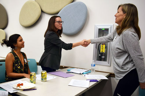 Mallory Garner-Wells shaking hands with Boulder attendees at advocacy training