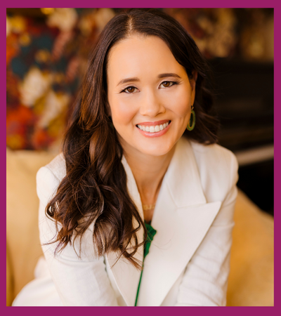 Tania Zeigler headshot - woman with long brown hair and white blazer smiling at camera